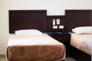 een hotelkamer met 2 bedden en een telefoon bij Sharks Bay Oasis Resort & Butterfly Diving Center in Sharm El Sheikh