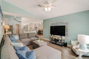 マルコ・アイランドにあるStunning 4BR Beach House - Pool - Spa - Near the Parkのソファと薄型テレビのあるリビングルーム