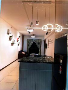 a kitchen with a counter top and a living room at K AVENUE GC kk house in Kota Kinabalu