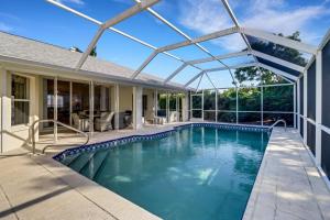 a swimming pool with a pergola over a house at 1969 Marco Island in Marco Island