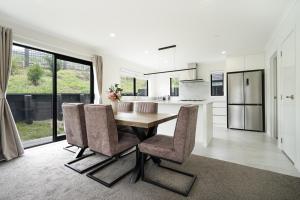 eine Küche und ein Esszimmer mit einem Holztisch und Stühlen in der Unterkunft Stunning 3 bedrooms house in Hillcrest - Close to Waikato University & Cambridge in Hamilton