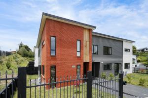 una casa de ladrillo con una valla delante de ella en Stunning 3 bedrooms house in Hillcrest - Close to Waikato University & Cambridge, en Hamilton