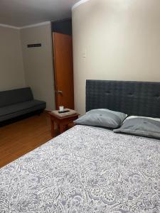 a bedroom with a large bed and a table at Hostal Alborada in Cajamarca