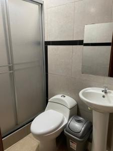 a bathroom with a toilet and a sink at Hostal Alborada in Cajamarca