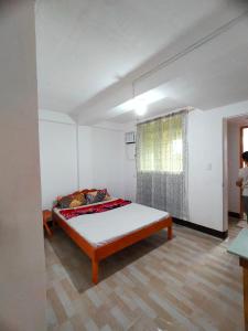 1 dormitorio con 1 cama en una habitación blanca en AUNORA ROOMS with AC and Kitchen, 