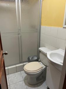 a bathroom with a shower and a toilet and a sink at Hostal Alborada in Cajamarca