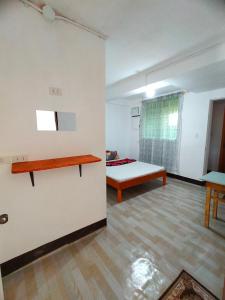 Sala de estar con cama y mesa en AUNORA ROOMS with AC and Kitchen, 