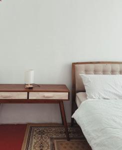 a bed and a nightstand next to a bed and a table at The Classy RomaAkar in Shah Alam