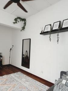 uma sala de estar com uma ventoinha de tecto e um espelho em The Classy RomaAkar em Shah Alam
