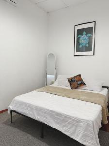 ein Schlafzimmer mit 2 Betten und einem Bild an der Wand in der Unterkunft The Classy RomaAkar in Shah Alam