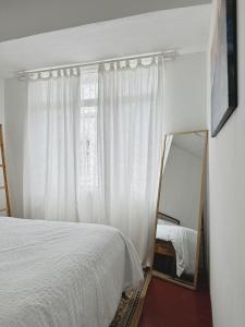 1 dormitorio con cama blanca y espejo en The Classy RomaAkar en Shah Alam