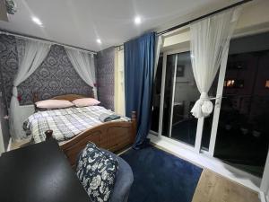 a bedroom with a bed and a large window at Rooms near Canary wharf in London