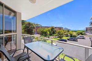 a balcony with a table and chairs and a view of a street at Seaspray Unit 3 4 Intrepid Close in Nelson Bay
