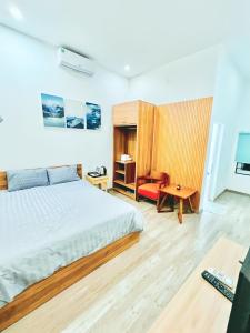 a bedroom with a bed and a desk and a chair at D'Villa Hotel - Homestay in Kon Tum