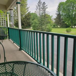 une balustrade verte sur une terrasse couverte avec une table dans l'établissement 26747 Barrington, à Barrington