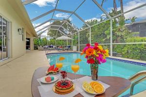 a table with food and drinks on it next to a pool at 363 Marco Island in Marco Island