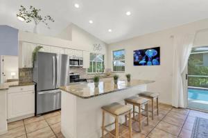 a kitchen with a large island with bar stools at 363 Marco Island in Marco Island