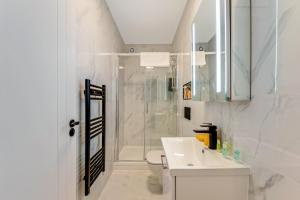 a white bathroom with a shower and a sink at Bright and Relaxing One Bedroom Flat in London