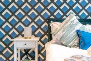 a bedroom with a blue and white checkered wall at Bright and Relaxing One Bedroom Flat in London