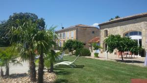 a garden with a white bench in front of a building at La Grange de La Dupuise in Civrac-de-Blaye