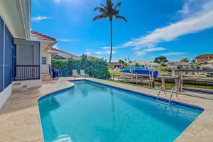 een zwembad met een patio en een palmboom bij 206 Marco Island in Marco Island