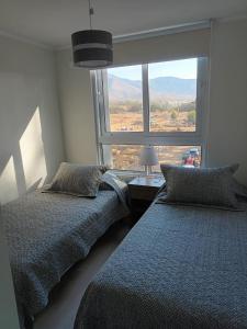 two beds in a bedroom with a large window at Lomas de Puyai in Agua Salada
