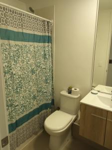 a bathroom with a toilet and a shower curtain at Lomas de Puyai in Agua Salada