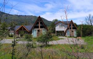 ein Haus mit einem Berg im Hintergrund in der Unterkunft Cabañas Nevados Del Valle in Malalcahuello