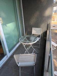 a glass table and two chairs on a balcony at Lomas de Puyai in Agua Salada