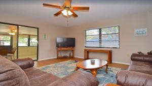 un soggiorno con un divano e un ventilatore a soffitto di 6795 Sarasota a Sarasota