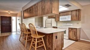 una cucina con armadi in legno e un'isola cucina con sgabelli. di 6795 Sarasota a Sarasota