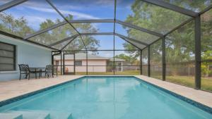 una piscina coperta con tetto in vetro, tavolo e sedie di 6795 Sarasota a Sarasota