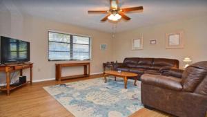 un soggiorno con un divano e un ventilatore a soffitto di 6795 Sarasota a Sarasota Altre 3 foto