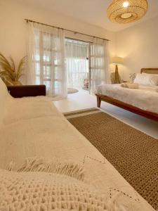 1 Schlafzimmer mit 2 Betten und einem großen Fenster in der Unterkunft Mediterranean 2Bdr Villa near Pererenan Beach in Canggu