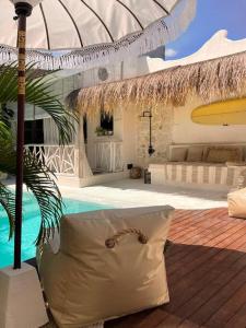 ein Resort mit Pool und Sonnenschirm in der Unterkunft Mediterranean 2Bdr Villa near Pererenan Beach in Canggu