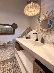 ein Bad mit einem Waschbecken und einem Spiegel in der Unterkunft Mediterranean 2Bdr Villa near Pererenan Beach in Canggu