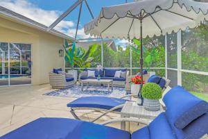 a patio with blue chairs and an umbrella at 363 Marco Island in Marco Island