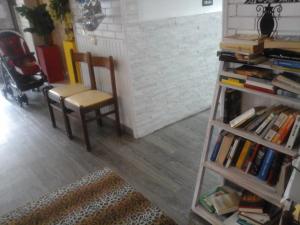 a chair sitting next to a book shelf with books at Villa Lavinia in Rimini +49 photos