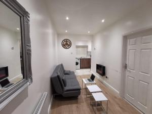 un soggiorno con sedia, tavolo e specchio di Three Bedroom Modern Apartment by Luton Airport and Luton Station a Luton