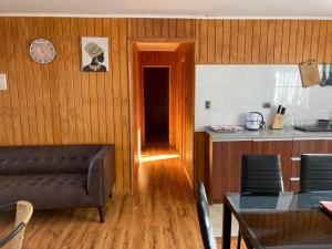 cocina con sofá y mesa en una habitación en Cabañas Las Márgaras Uno, en Llanquihue