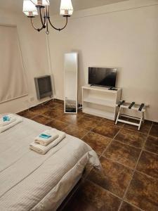 1 dormitorio con 1 cama y TV de pantalla plana en Dpto amplio con vista a la bahía en Ushuaia