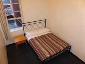 a small bed in a room with a window at Maze Backpackers - Sydney in Sydney +51 photos