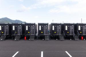 a row of black containers sitting in a parking lot at HOTEL R9 The Yard 柳井 