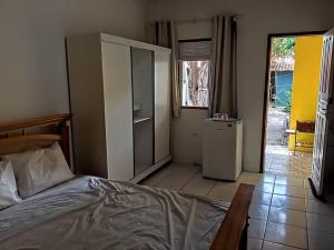 1 dormitorio con 1 cama y cocina con nevera en Suíte em Cumuruxatiba beira-mar en Cumuruxatiba