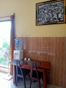 Tirtagangga的住宿－Alamku Bungalow，一张桌子、两把椅子和微波炉