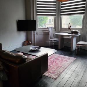 a living room with a couch and a table at 10 Large Elegant Studio - Prime Location - Comfortable - Private in Brighton & Hove