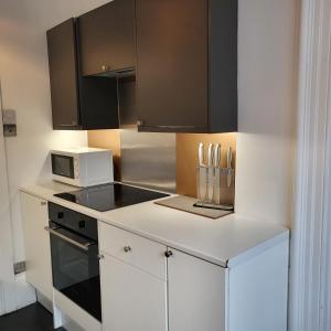 a kitchen with a white counter top with a microwave at 10 Large Elegant Studio - Prime Location - Comfortable - Private in Brighton & Hove