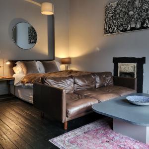 sala de estar con sofá de cuero y mesa en 10 Large Elegant Studio - Prime Location - Comfortable - Private en Brighton & Hove