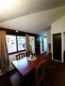 - une salle à manger avec une table et des chaises en bois dans l'établissement Terrazas del Venado, à La Cumbre