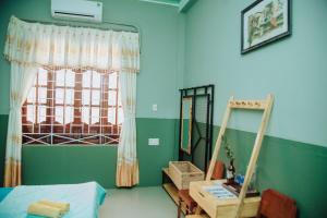 a bedroom with a bed and a window and a desk at Trại Hoa Vàng Homestay at Tuy Hòa Phú Yên in Ðông Tác (1)